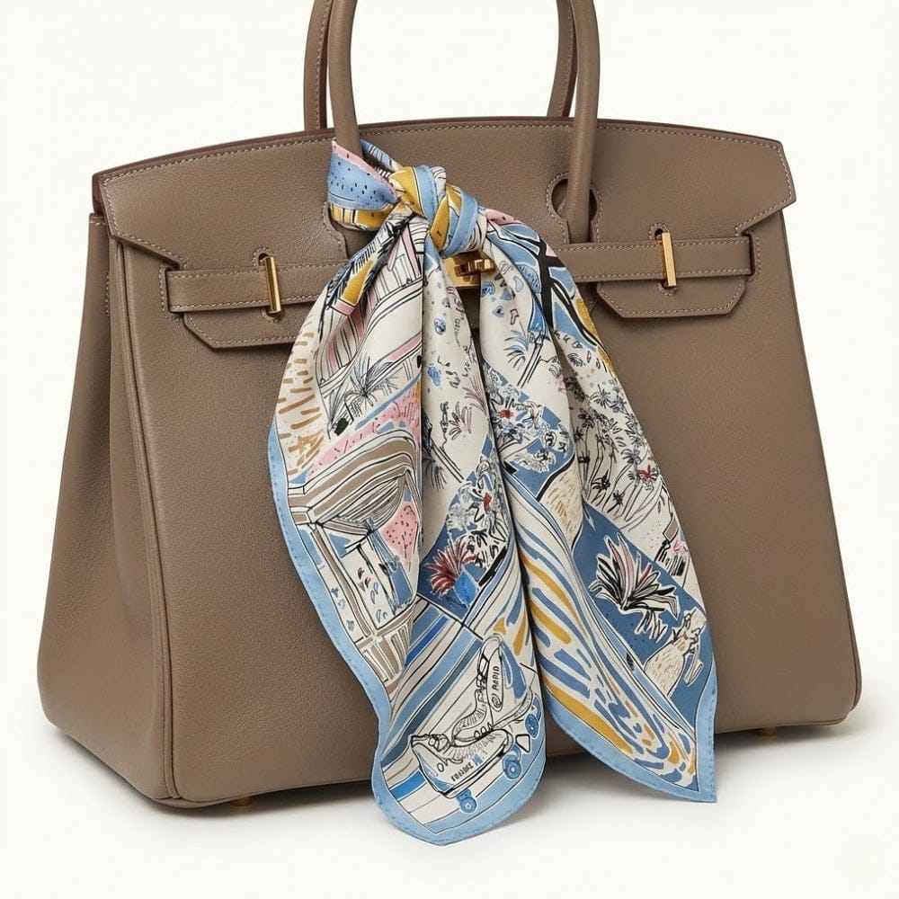 Foulard carré en soie aux motifs colorés, noué sur un sac à main beige élégant