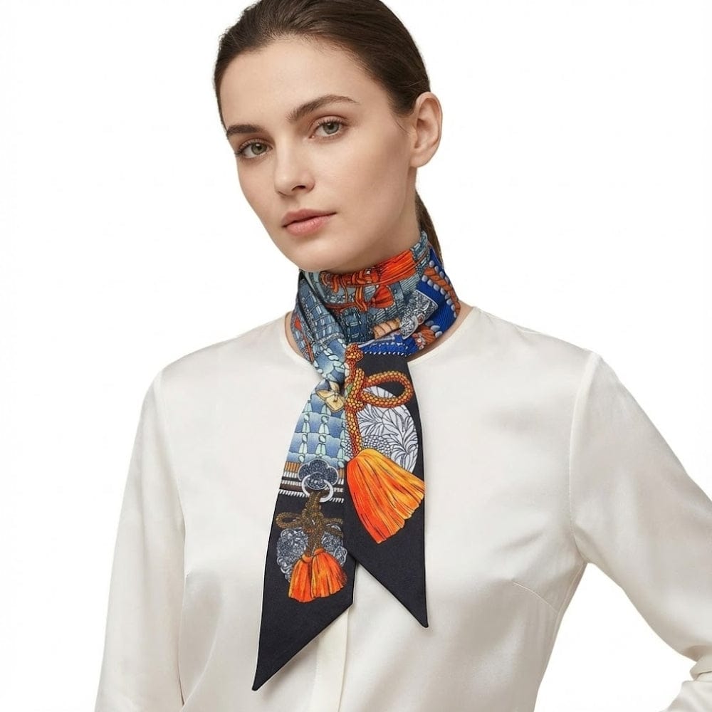 Foulard en soie aux motifs colorés, noué autour du cou d'une femme, ajoutant une touche chic à une blouse blanche