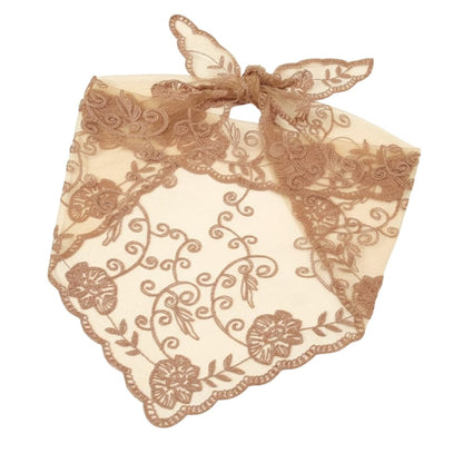 Foulard en dentelle beige avec motifs floraux, noué délicatement, évoquant une élégance romantique et douce