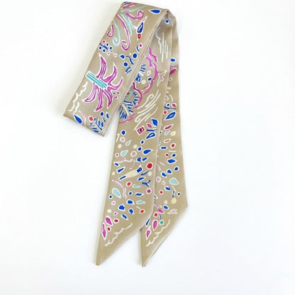 Foulard en satin beige avec motifs colorés, idéal comme bandeau chic pour cheveux