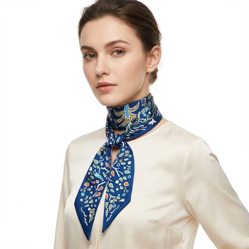 Foulard en satin bleu avec motifs floraux colorés noué autour du cou d'une femme élégant