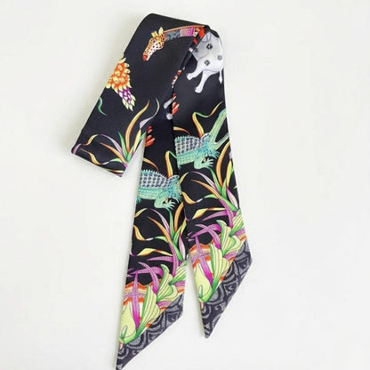 Foulard en satin noir avec motifs colorés d'animaux et de fleurs, noué de manière élégante