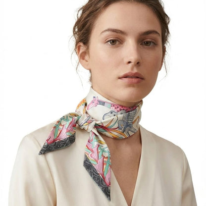 Foulard en soie noué autour du cou, motifs colorés de fleurs et d'animaux, porté par une femme