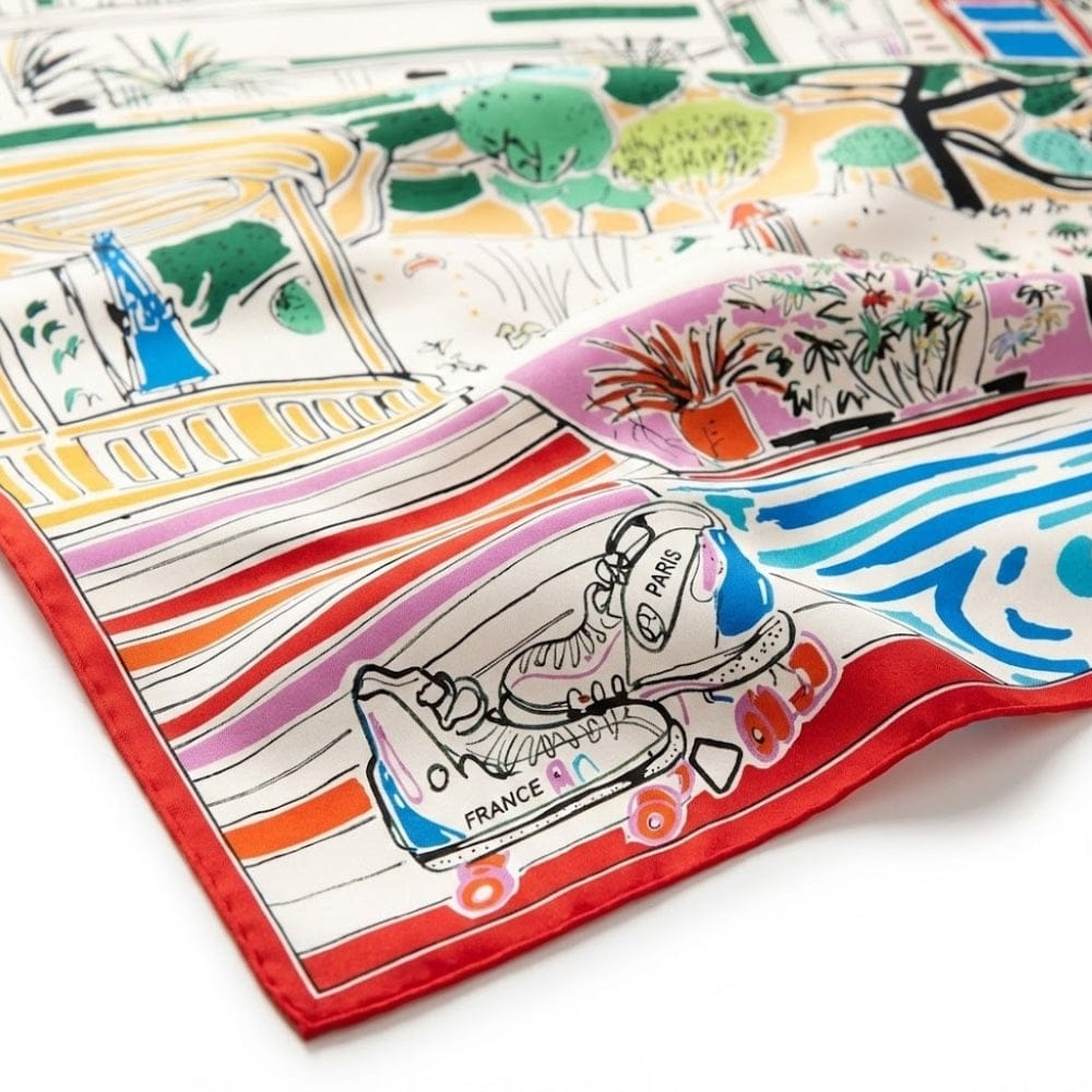Foulard carré en soie aux motifs colorés illustrant des scènes de Paris, avec un bord rouge vif