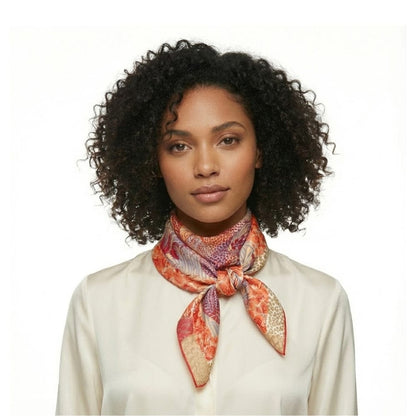 Foulard carré en satin aux motifs colorés, noué autour du cou d'une femme avec une blouse claire
