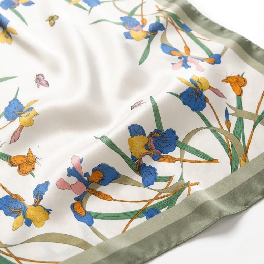 Foulard en satin blanc orné de motifs floraux colorés, avec des touches de bleu, jaune et vert
