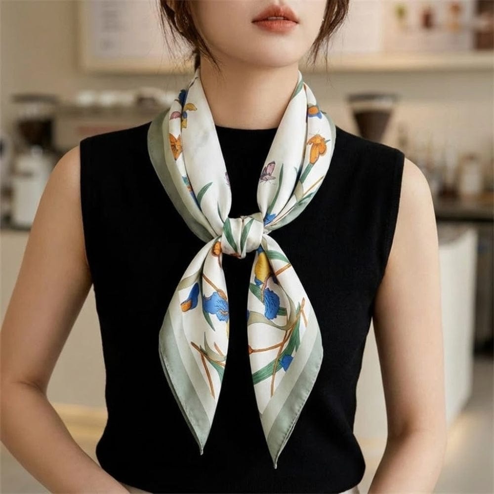 Foulard en soie aux motifs floraux colorés, noué élégamment autour du cou d'une femme