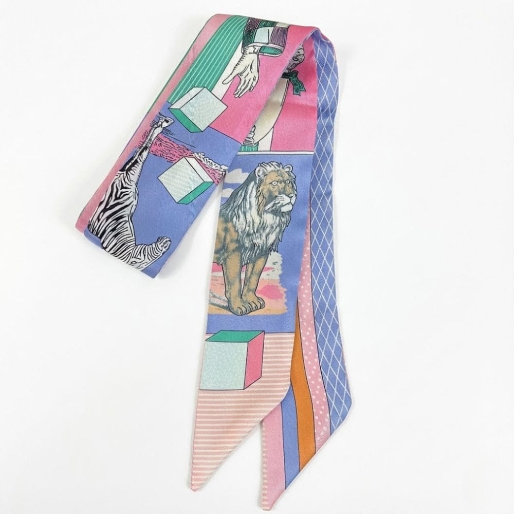 Foulard en satin multicolore avec motifs animaliers et géométriques, noué élégamment sur un fond blanc