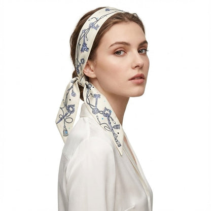 Foulard bandeau en soie crème avec motifs bleus, noué élégamment sur une femme au style raffiné