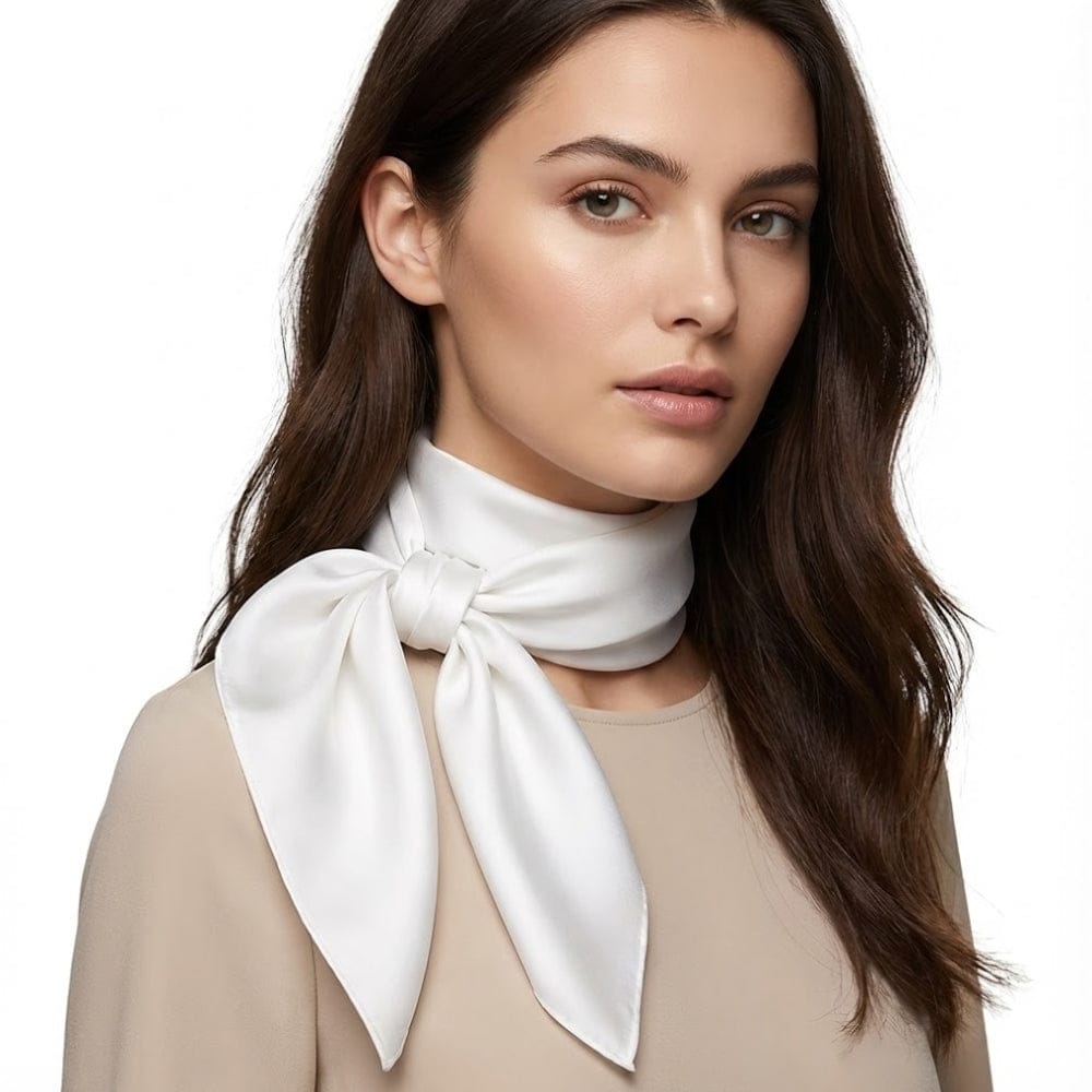 Foulard en satin blanc noué autour du cou d'une femme, apportant une touche de féminité subtile