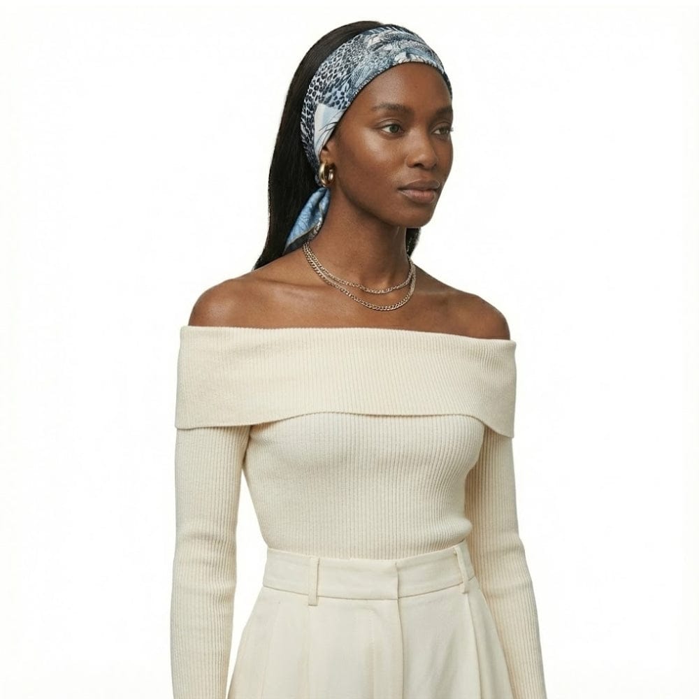 Foulard en soie bleu avec motif léopard, porté en bandeau par une femme au look sophistiqué