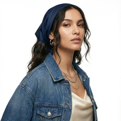 Foulard en satin bleu marine noué sur la tête, porté par une femme avec une veste en jean
