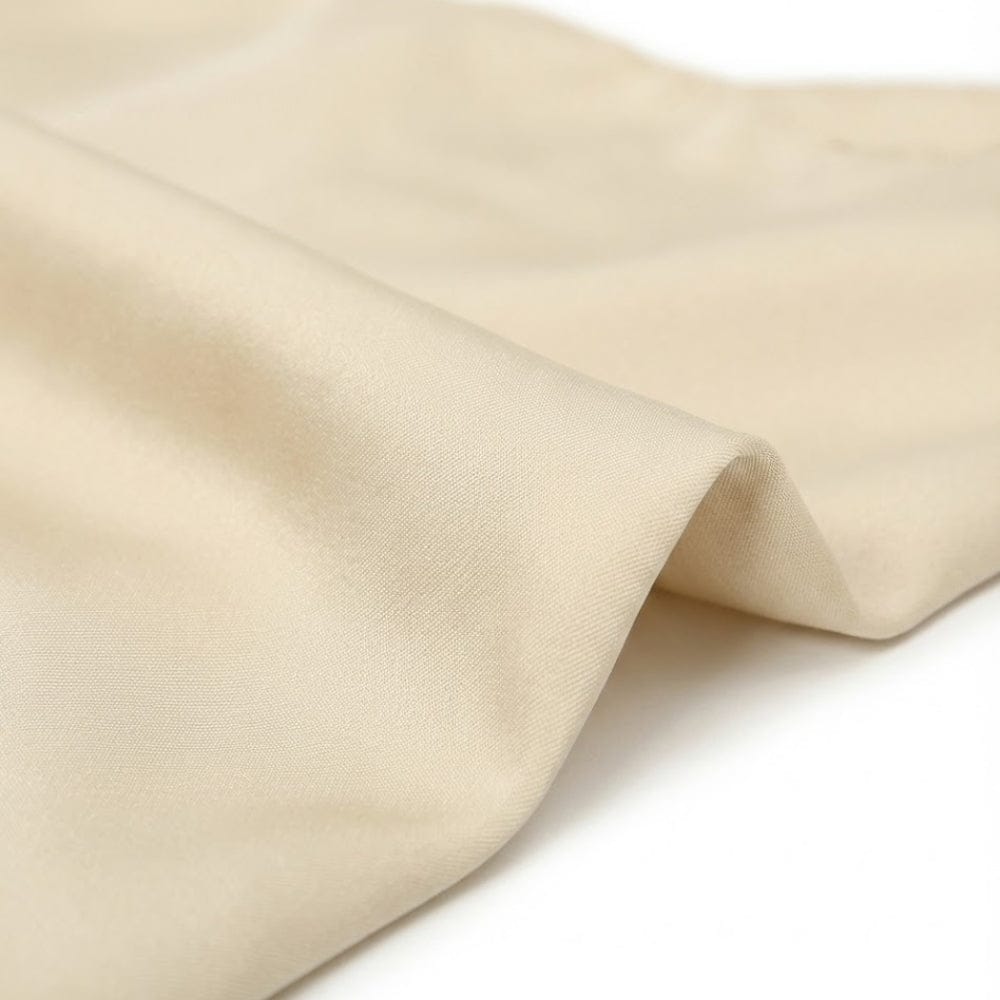 Foulard carré en satin beige, doux au toucher, drapé élégamment sur un fond blanc