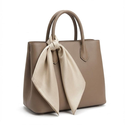 Foulard en satin beige noué sur un sac à main en cuir marron, ajoutant une touche d'élégance