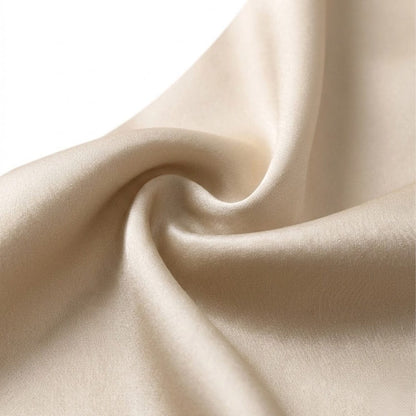 Foulard carré en soie de couleur crème, avec une texture lisse et brillante, délicatement plié
