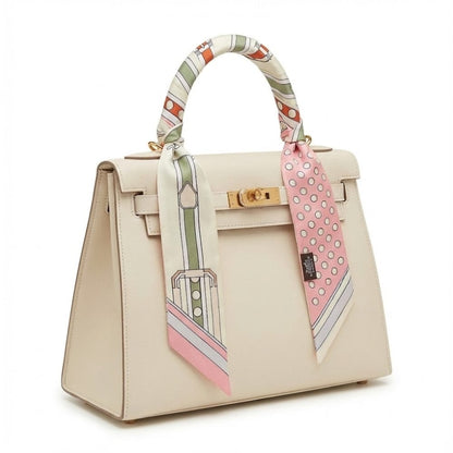 Foulard en soie noué sur une poignée de sac, avec motifs colorés et élégants, ajoutant une touche chic