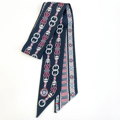 Foulard en satin bleu marine avec motifs géométriques et graphiques, noué élégamment sur une femme