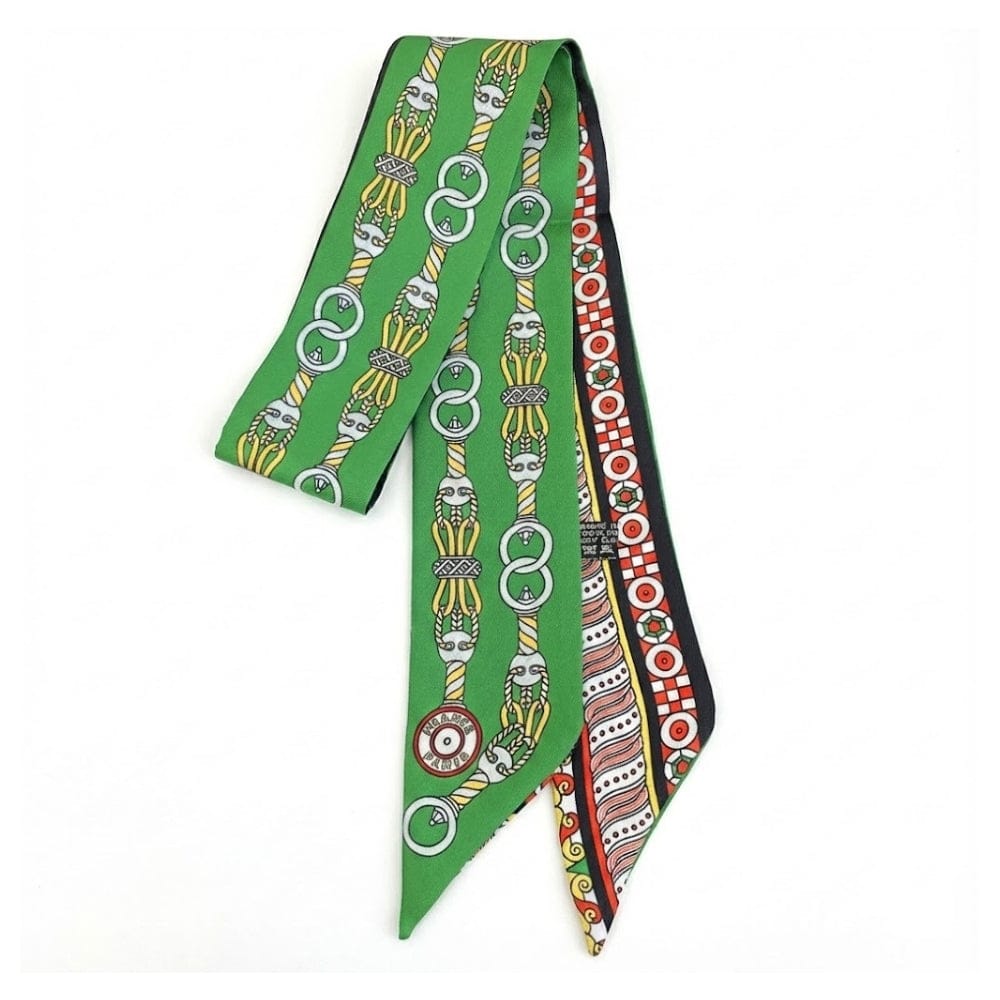 Foulard en soie vert avec motifs graphiques colorés, noué élégamment, parfait pour un look féminin moderne
