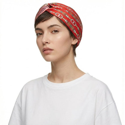 Foulard en satin rouge avec motifs graphiques, noué sur la tête d'une femme aux cheveux courts