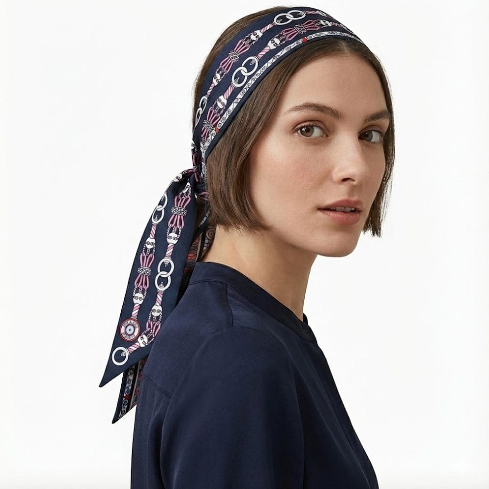 Foulard en satin bleu marine à motifs graphiques, noué sur une coiffure courte, porté par une femme