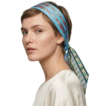 Foulard en soie bleu à motifs colorés noué sur une coiffure courte, porté par une femme élégante