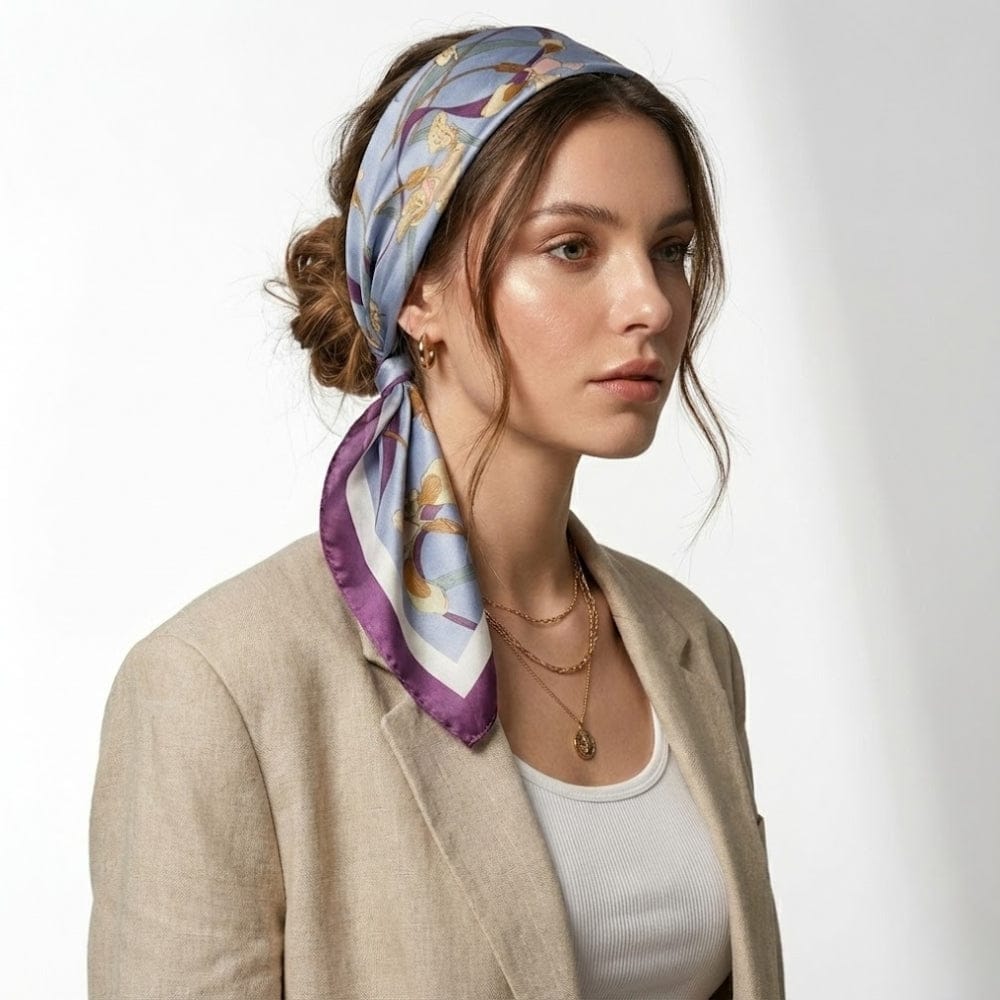 Foulard en satin bleu à motifs floraux, noué sur la tête d'une femme au look élégant, portant un blazer beige
