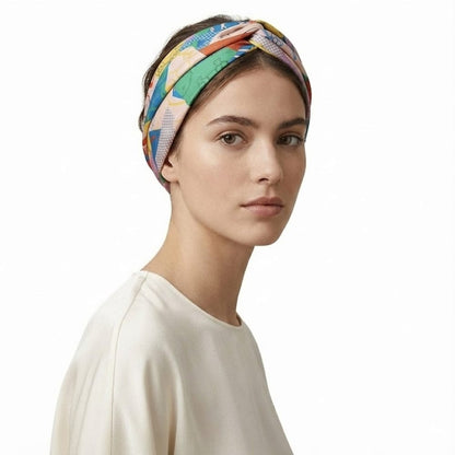 Foulard coloré en satin avec motifs géométriques, porté en bandeau par une femme au teint naturel
