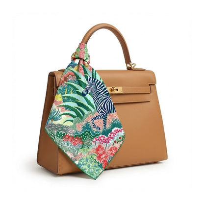 Foulard carré aux motifs colorés de zèbre et de fleurs, noué sur un sac à main beige élégant