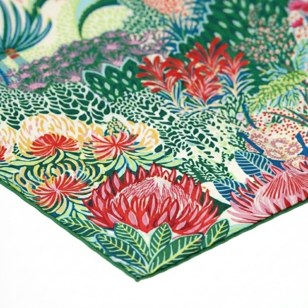 Foulard en soie coloré avec motifs floraux sur fond vert, idéal pour un look chic et élégant