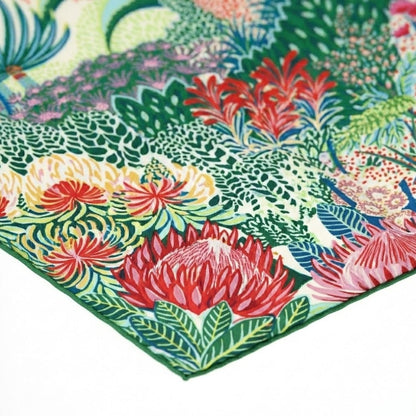 Foulard en soie coloré avec motifs floraux sur fond vert, idéal pour un look chic et élégant