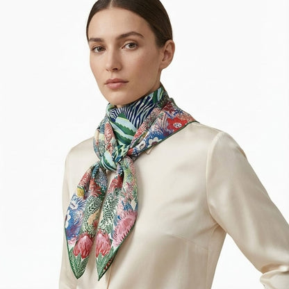 Foulard en soie coloré avec motifs floraux et zébrés, noué élégamment autour du cou d'une femme