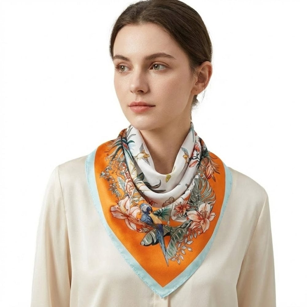 Foulard en satin carré aux motifs floraux colorés, porté par une femme au cou, ajoutant une touche d'élégance