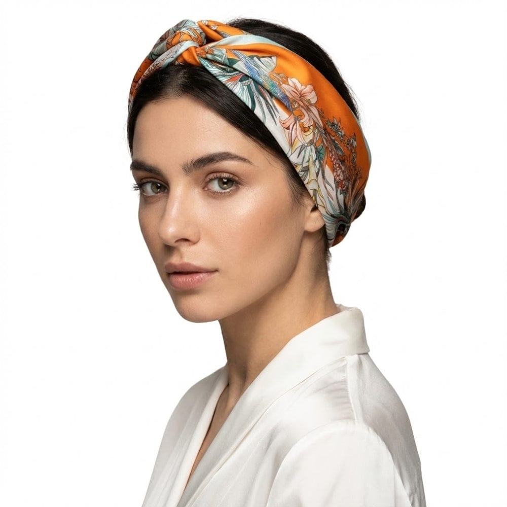 Foulard en soie aux motifs floraux orange et blanc, noué sur la tête d'une femme élégante