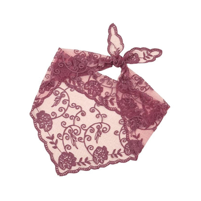 Foulard en dentelle bordeaux avec motifs floraux brodés, noué en forme de triangle sur fond rose
