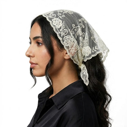 Foulard en dentelle écru, délicatement noué sur une femme, ajoutant une touche bohème à sa tenue