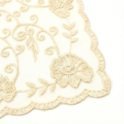 Foulard en dentelle teinte écru avec des motifs floraux délicats, idéal pour une touche bohème élégante