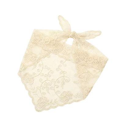 Foulard en dentelle écrue avec motifs floraux, noué délicatement, apportant une touche bohème élégante