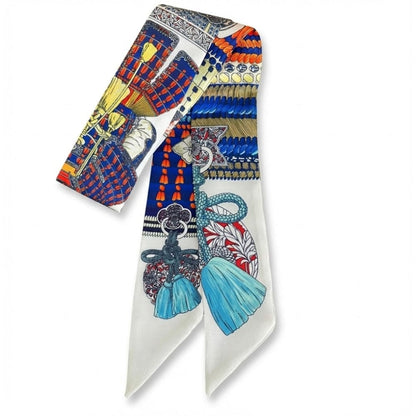 Foulard en soie aux motifs colorés, bleu et rouge, avec des franges et des détails élégants, idéal pour un look