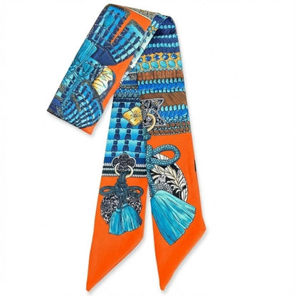 Foulard en satin aux motifs géométriques bleus et orange, noué en bandeau sur une femme