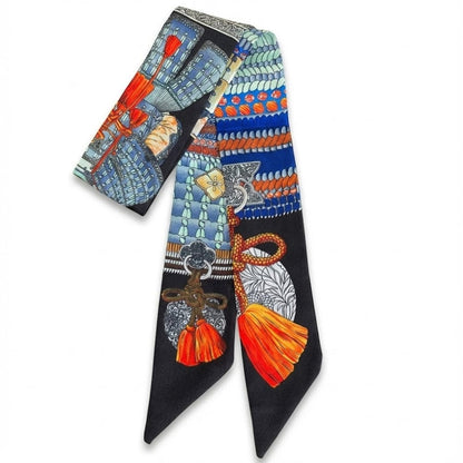 Foulard en soie aux motifs colorés avec des touches de bleu, orange et noir, présenté sur fond blanc