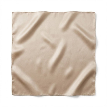 Foulard carré en soie de couleur beige, au toucher lisse et brillant, posé sur un fond blanc