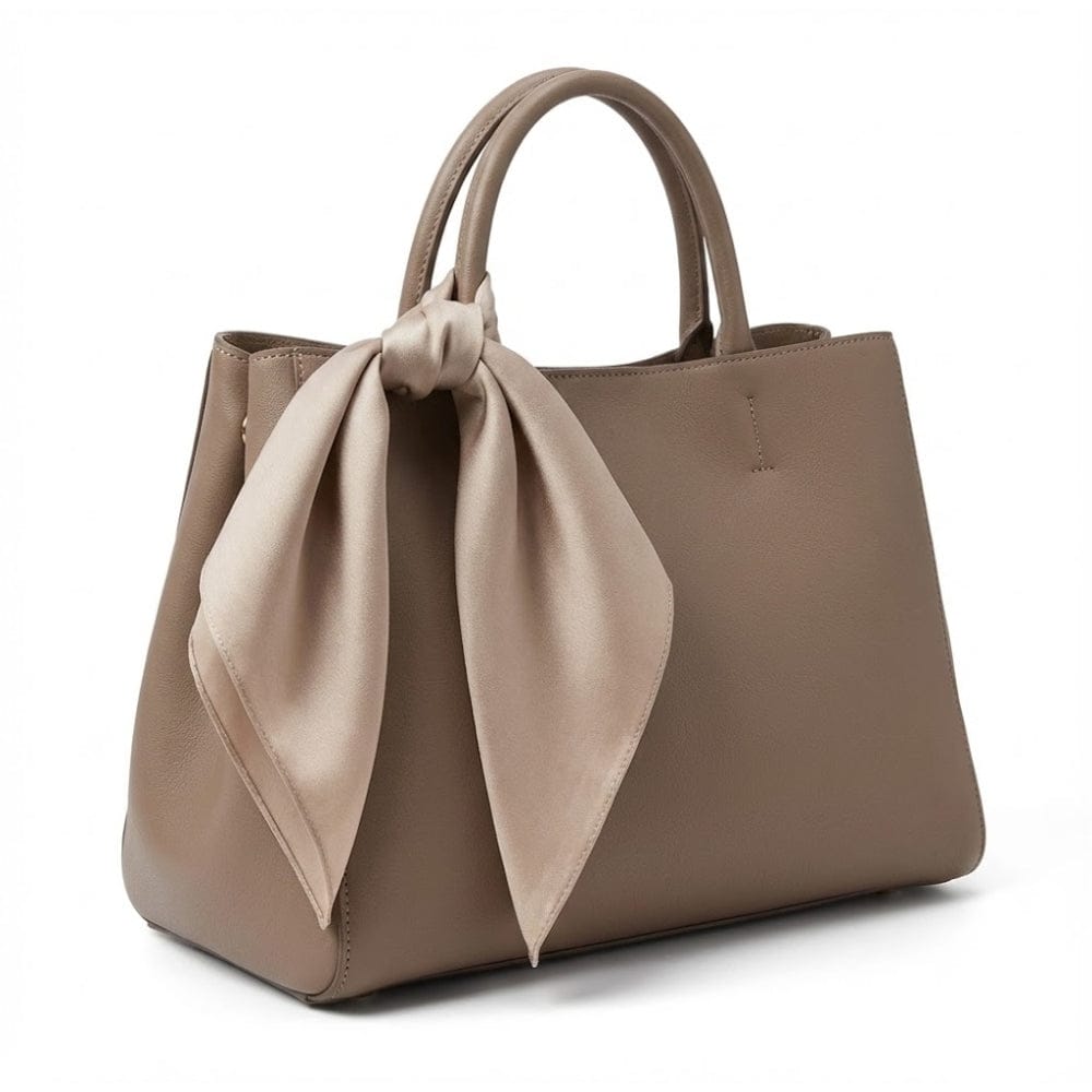 Foulard en satin noué sur un sac à main beige, ajoutant une touche d'élégance et de luxe