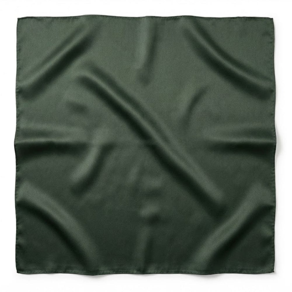 Foulard carré en soie de couleur vert foncé, au fini lisse et brillant, posé sur une surface blanche