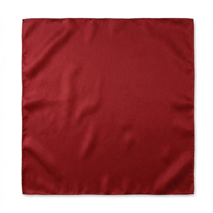 Foulard carré en soie rouge, au fini brillant, posé sur une surface blanche, mettant en valeur son allure sophistiquée
