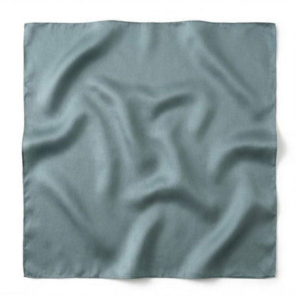 Foulard carré en soie vert d'eau, au toucher doux et à l'élégance intemporelle, posé sur un fond neutre