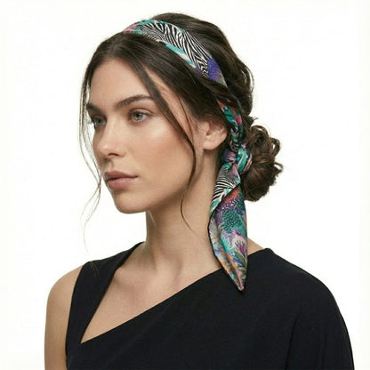 Foulard en satin à motifs zèbre et floral, porté en bandeau par une femme avec un top noir