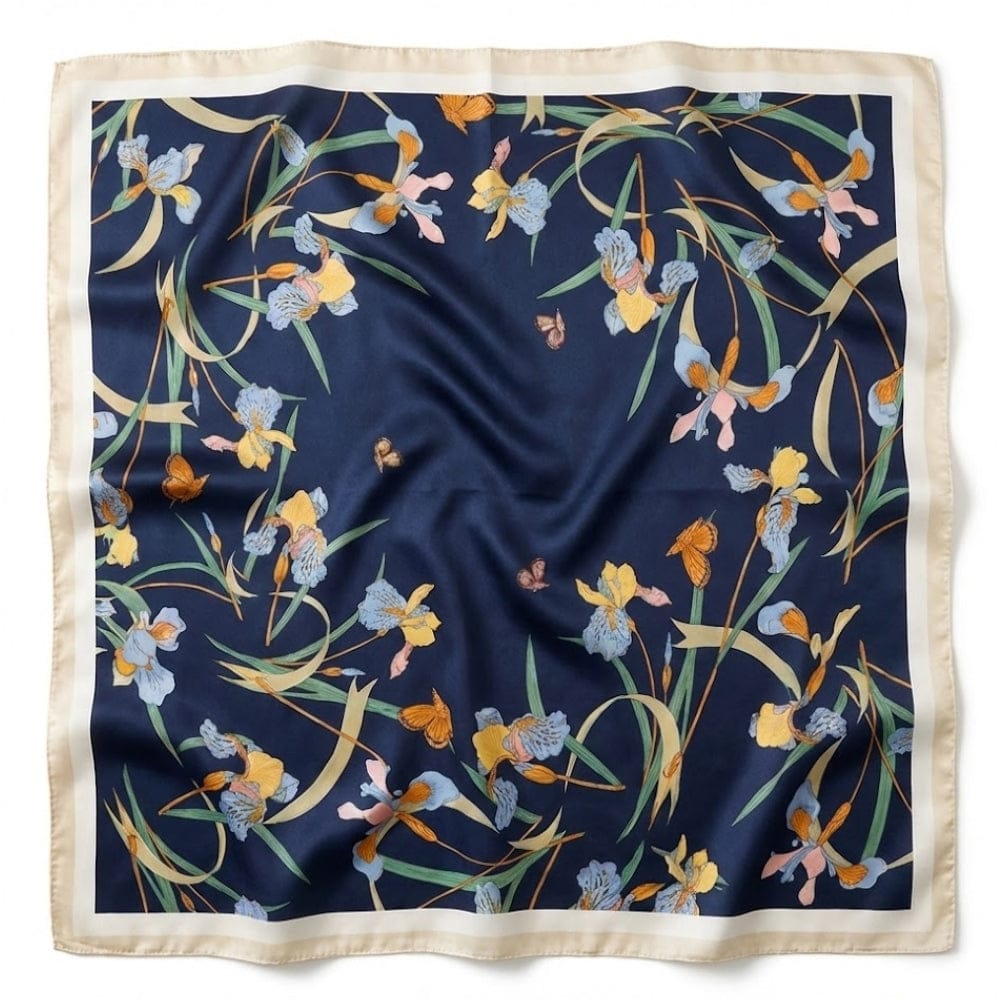 Foulard carré en satin avec motifs floraux colorés sur fond bleu marine, bordé d'une finition beige élégante