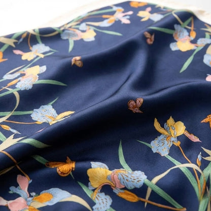 Foulard en satin bleu marine orné de motifs floraux colorés et délicats, idéal comme accessoire chic