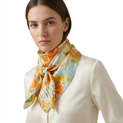 Foulard en soie aux motifs colorés, orange éclatant et bleu, noué élégamment autour du cou d'une femme
