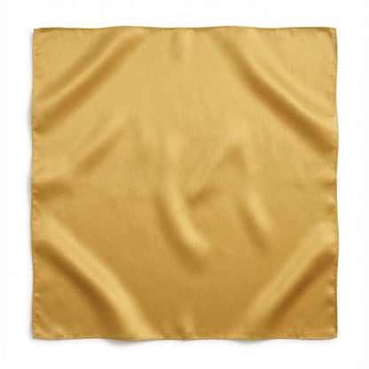 Foulard carré en soie jaune moutarde, au toucher lisse et brillant, posé sur un fond neutre